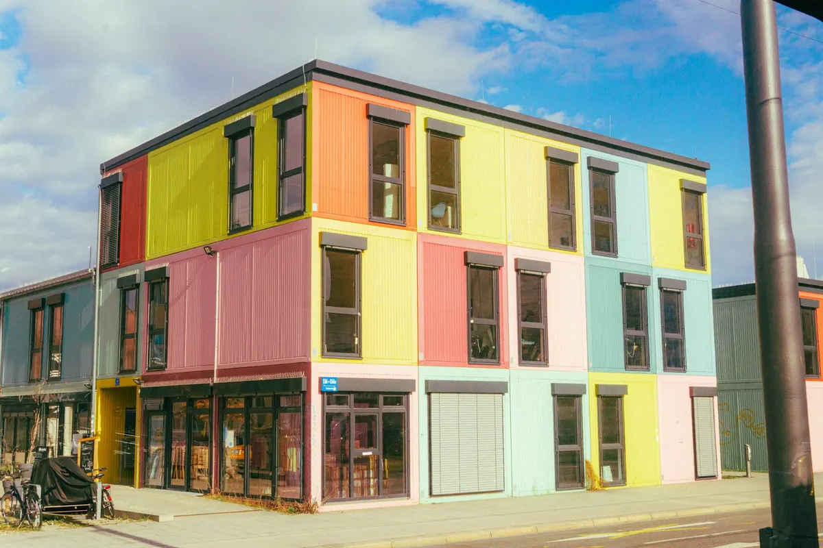 Three-storey modular building with a panelled façade and rows of windows.