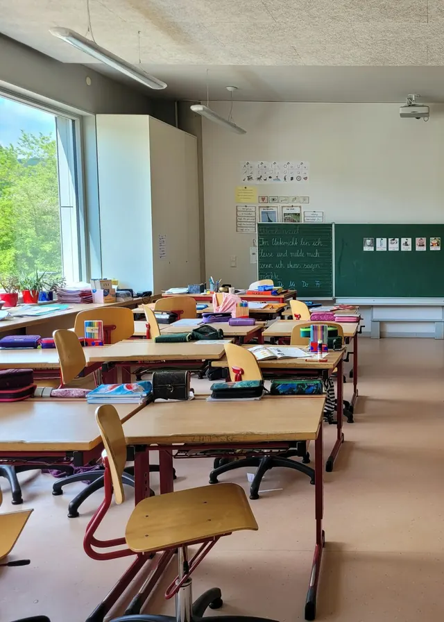 Primary school classroom with desks and a large window