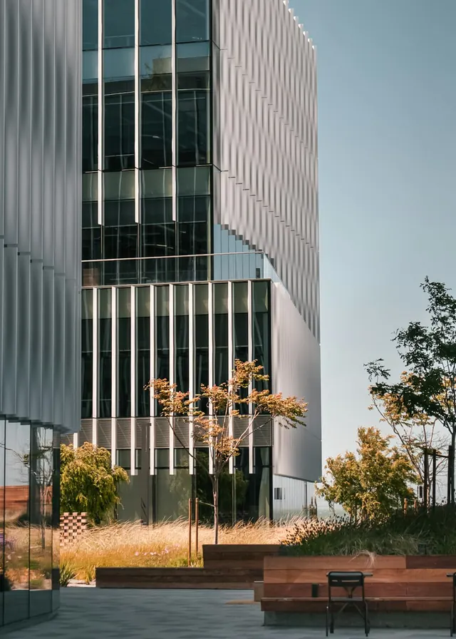 Glass office building façade with a landscaped courtyard